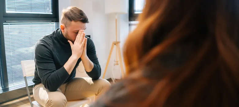 man with hands in face