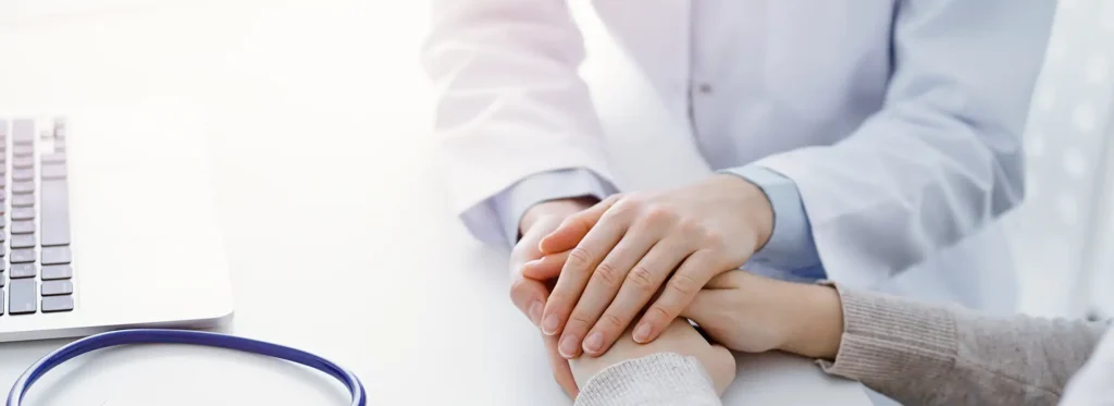 doctor-patient-sitting-table-clinic-office-focus-is-female-physician-s-hands-reassuring-woman-only-hands-close-up-medicine-concept