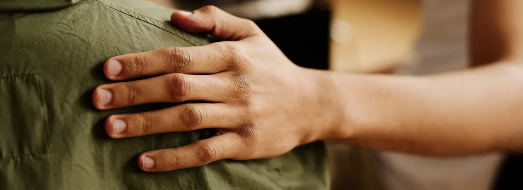 hand-young-supportive-man-consoling-his-friend-with-post-traumatic-syndrome