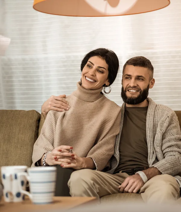 hugging-each-other-dark-haired-cute-couple-sitting-extremely-close-each-other-while-watching-tv-living-room