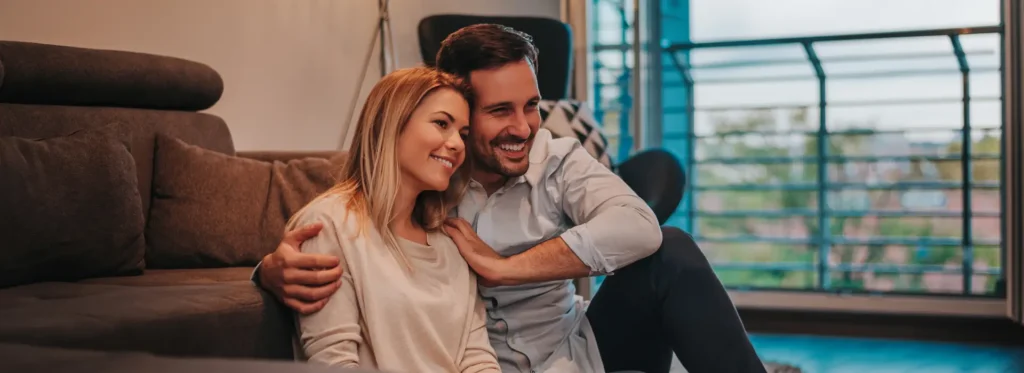 relaxing-new-house-cheerful-young-couple-sitting-floor-hugging