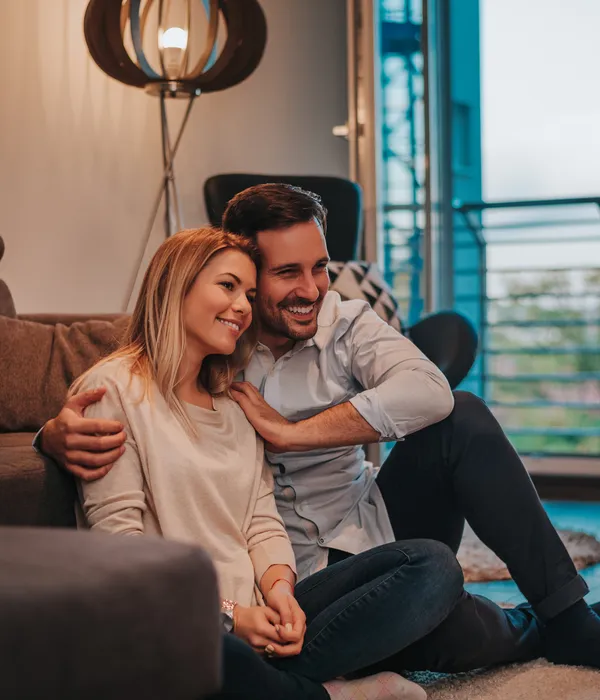 relaxing-new-house-cheerful-young-couple-sitting-floor-hugging
